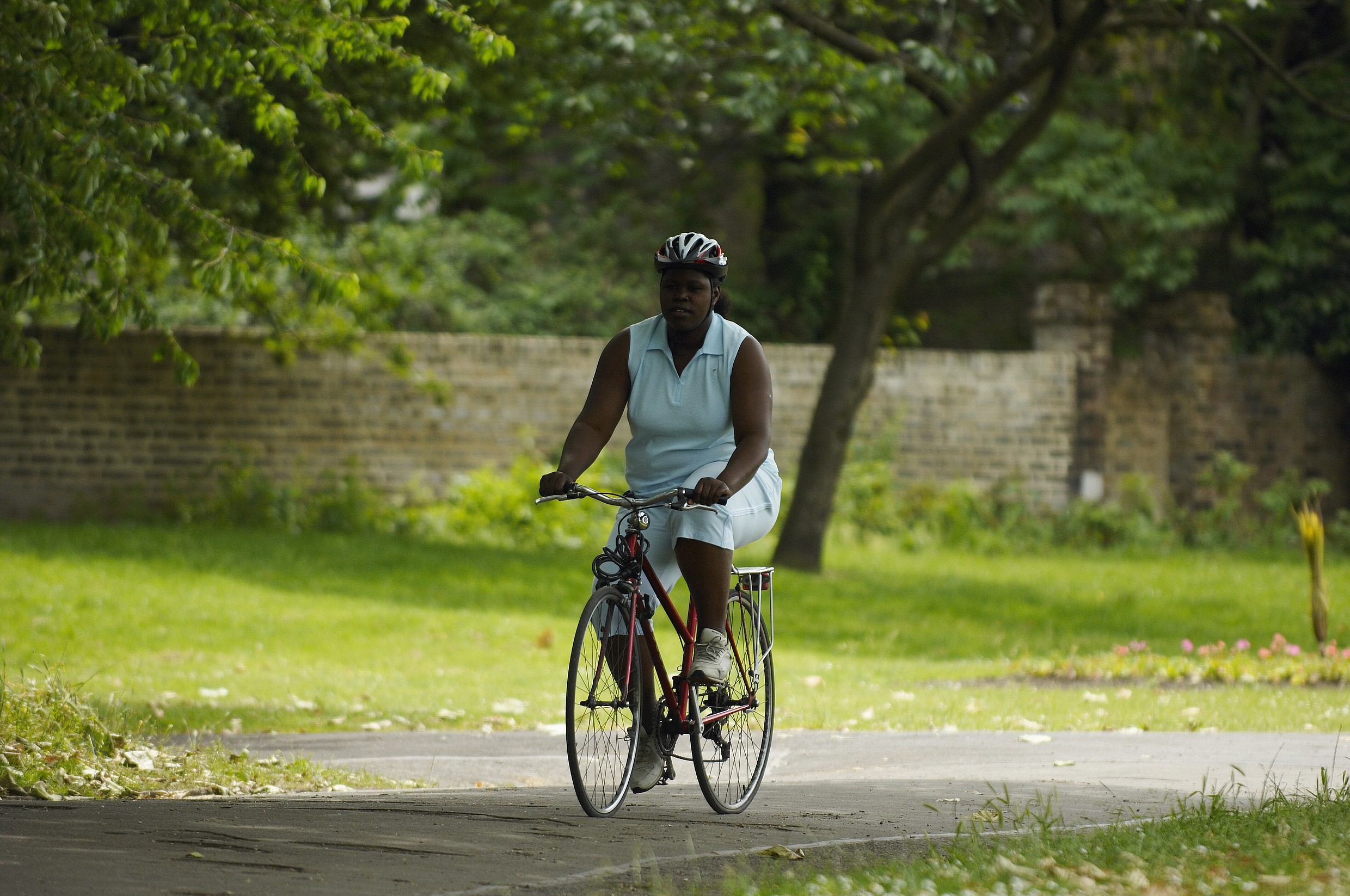 Unique ID: obes097 Caption: Obese black female, exercising, cycling in the park Restrictions: NHS Photo Library – for use in NHS, local authority social care services and Department of Health material only Copyright: ©Crown Copyright