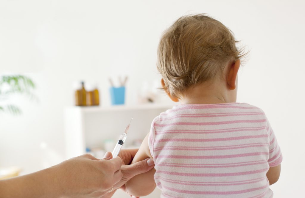 Back view of a baby receiving a vaccination